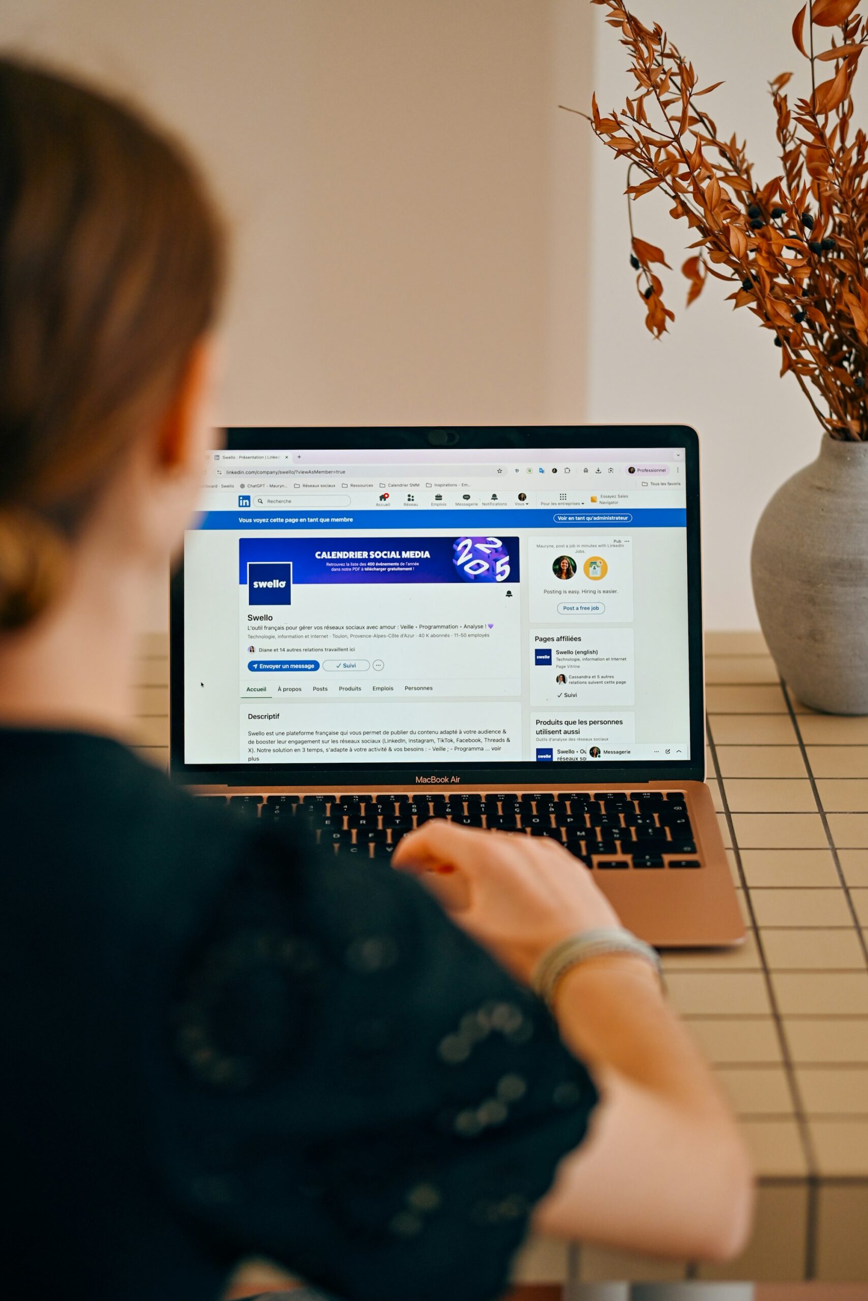 Persona trabajando en laptop con contenido de redes sociales